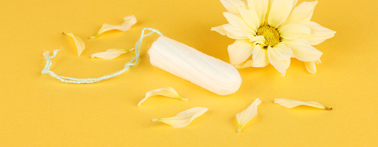 Tampon mit Tamponrückholfaden und Blume auf gelbem Grund